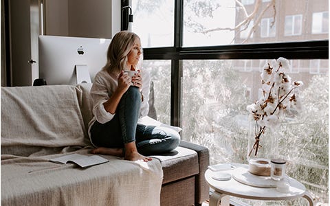 Woman drinking a cup of tea inside