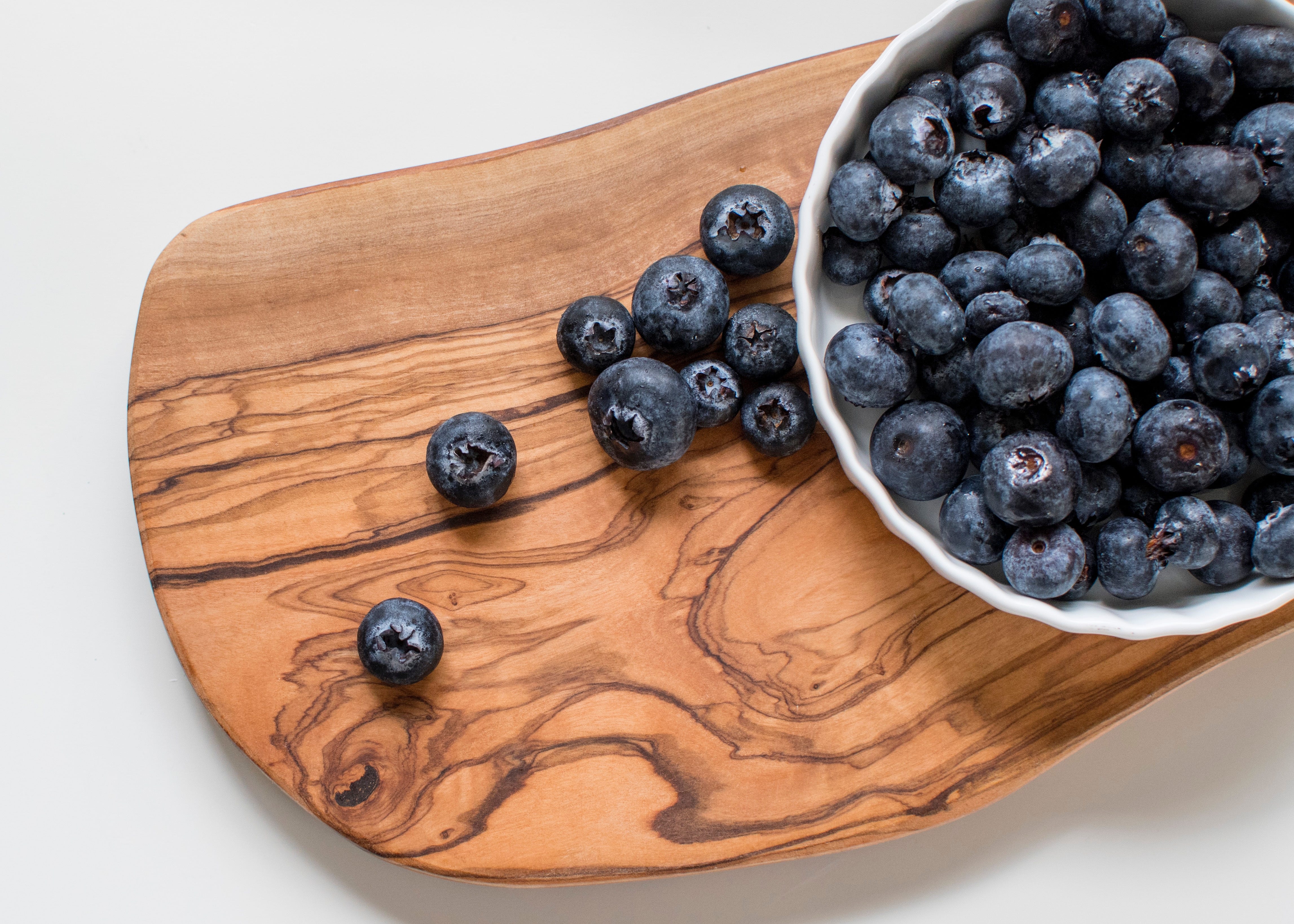 Bowl of blueberries on a wooden board