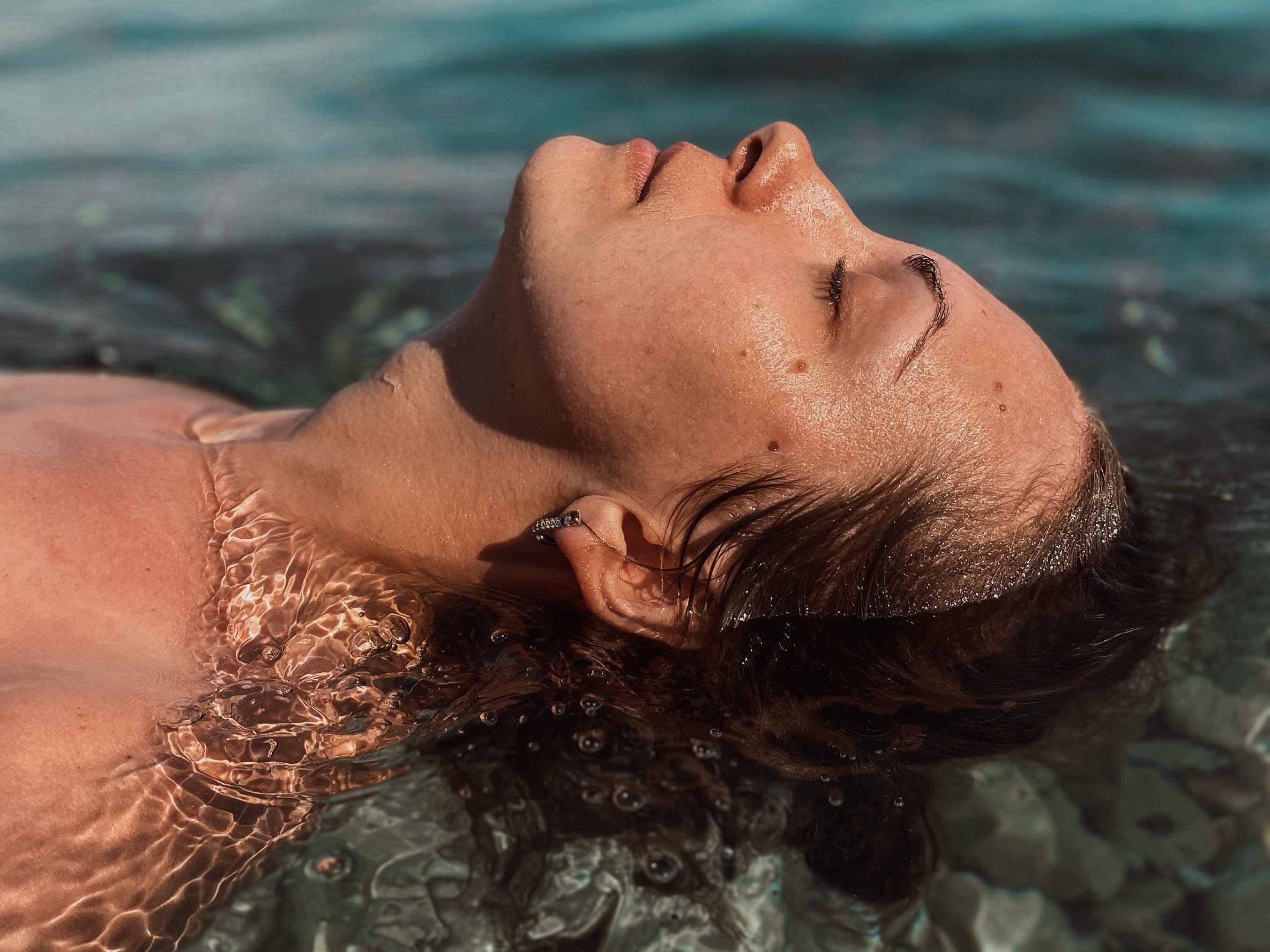 Profile of a woman's head leaning back into water