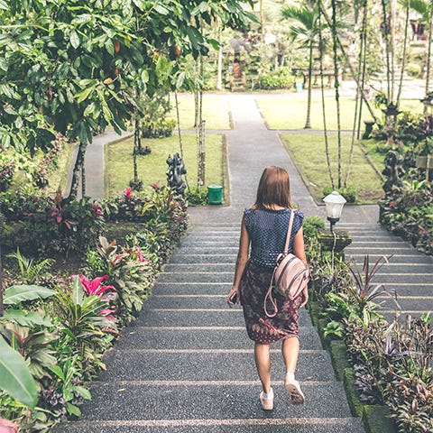 Woman walking down stairs in a green park