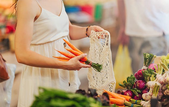 Woman grocery shopping for vegetables