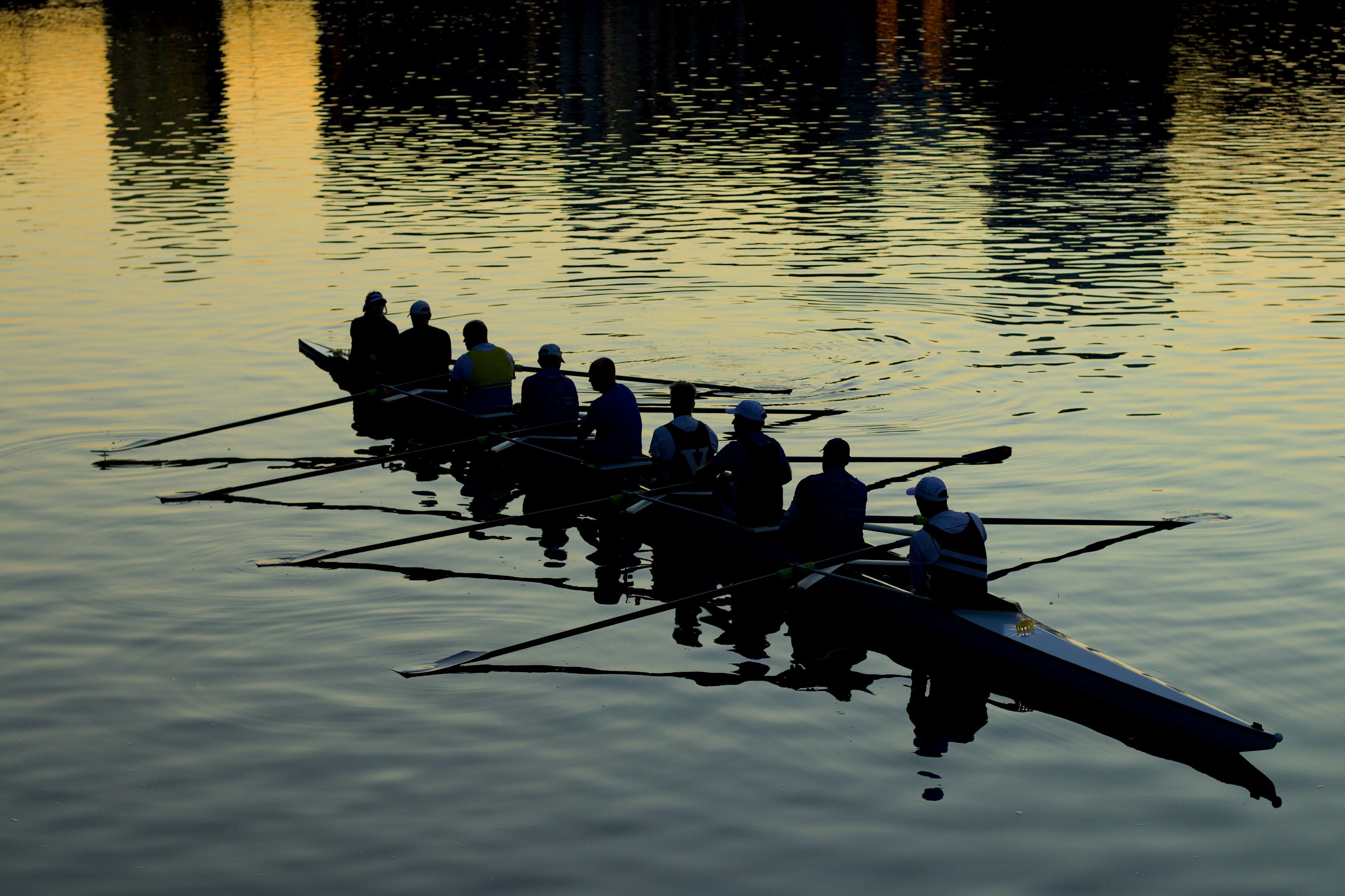 Team rowing on river making weight